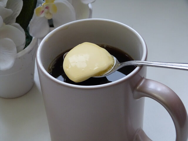 コーヒーにバターを入れてバターコーヒーを作っている写真